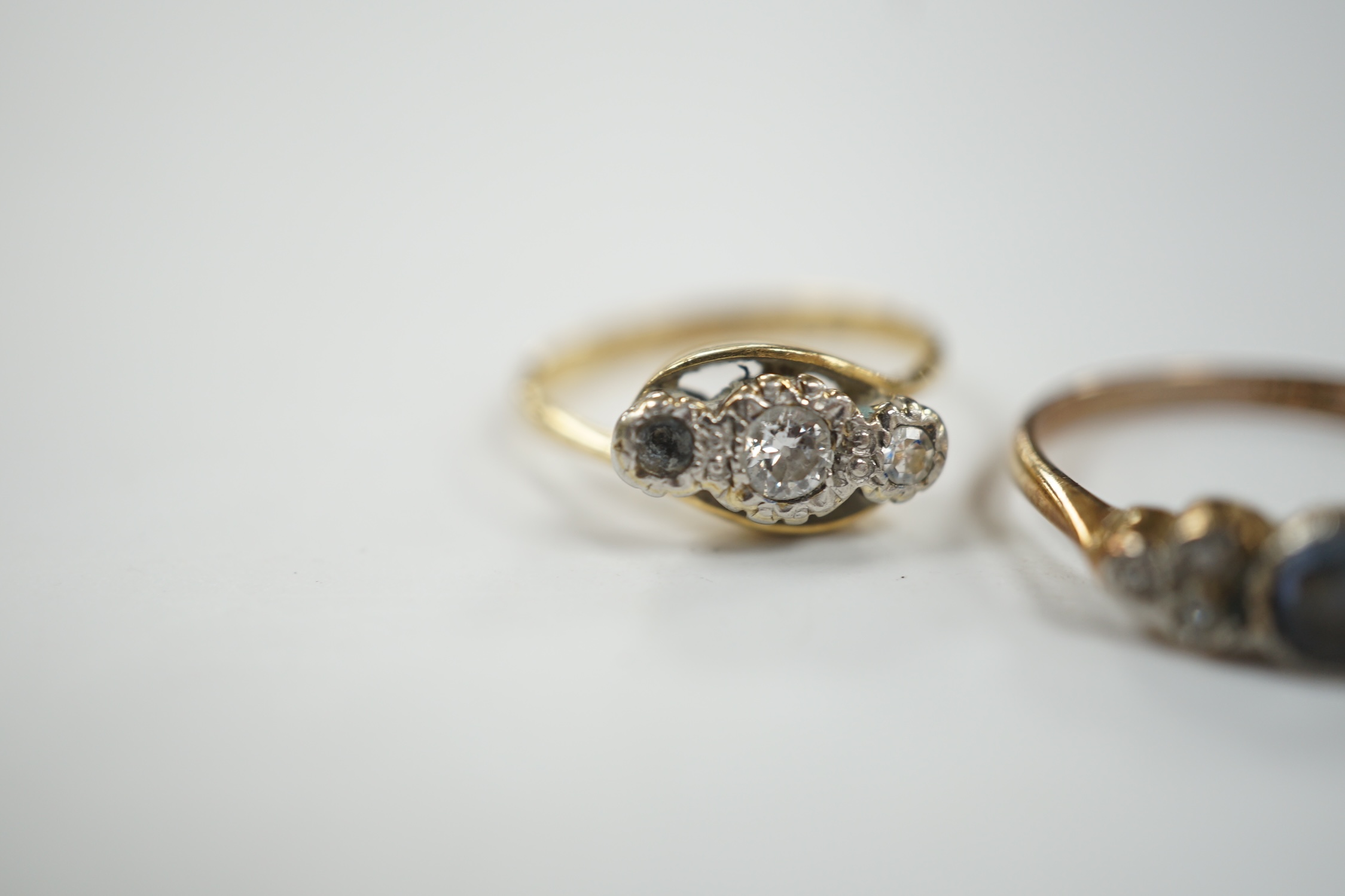 A 1920's/1930's 18ct and plat. single stone sapphire and six stone diamond set dress ring, size P/Q, together with an 18ct, plat and two (ex three) stone diamond set crossover ring, gross weight 5.4 grams.